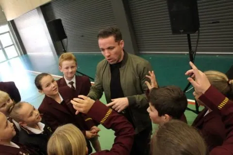 jonny shannon speaking to small circle of school children