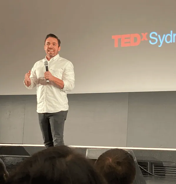jonny shannon speaking on stage at TEDx talks Sydney Australia